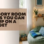 A blog post header banner graphic featuring a cozy, calming space with a plush green bean bag chair, an essential oil diffuser on a string-lit wall shelf, and text that reads "SENSORY ROOM IDEAS YOU CAN SET UP ON A BUDGET" to offer affordable sensory room ideas.